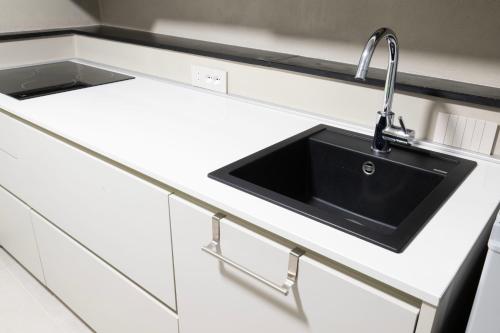 a kitchen counter with a black sink in it at Mirabel Apartments Moneglia - Cinque Terre in Moneglia