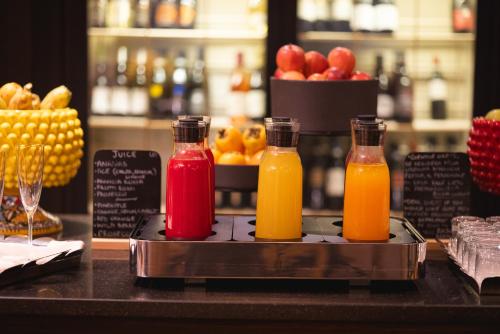 three bottles of juice on a counter with fruit at Palace Catania | UNA Esperienze in Catania