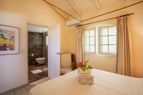 a bedroom with a bed and a bathroom at Villa Dol fijn huis in Willemstad