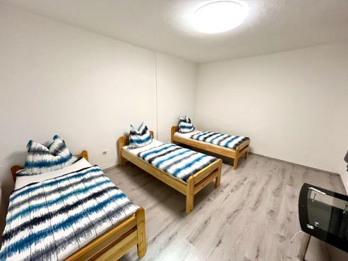 Cette chambre comprend 2 lits avec des oreillers bleus et blancs. dans l'établissement Häuschen für Monteure, Autobahn, à Bruck an der Mur