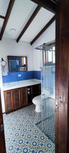 a bathroom with a toilet and a glass shower at Cabañas Nazak Lago 1 in Pereira