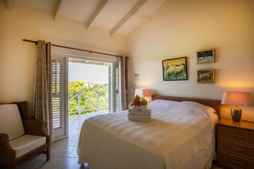 a bedroom with a bed and a chair and a window at Villa Dol fijn huis in Willemstad