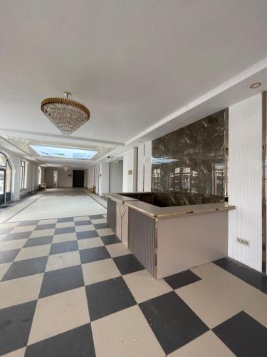 Großes Zimmer mit kariertem Boden und einem Kronleuchter in der Unterkunft Apartments Жк Авангард in Bischkek