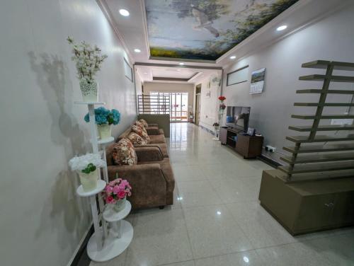 ein Wohnzimmer mit Sofa und Blumen an der Wand in der Unterkunft RT Mutbu&Tukthuan in Aizawl