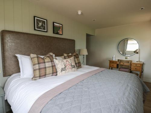 a bedroom with a large bed and a mirror at Orton Cottage in Appleby