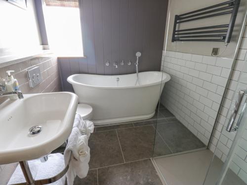 a bathroom with a tub and a toilet and a sink at Orton in Appleby