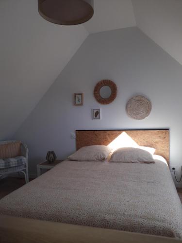 een slaapkamer met een groot bed met 2 kussens bij Le Grand Chêne in Condette