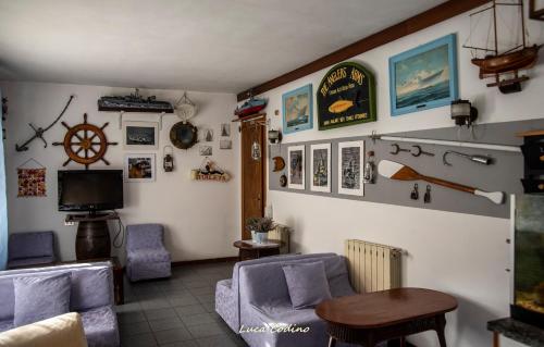 ein Wohnzimmer mit einem Sofa, Stühlen und einem TV in der Unterkunft Albergo La Marinella in Varraze