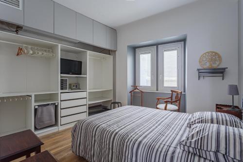 - une chambre blanche avec un lit, une table et une chaise dans l'établissement REPUBLIQUE Plein centre historique et à 2 pas de la grande plage, à Saint-Jean-de-Luz