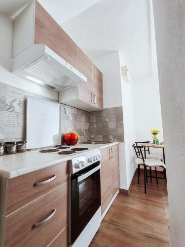 a kitchen with wooden cabinets and a stove top oven at Apartment Libar with Terrace and private Parking in Mostar