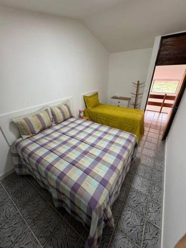 a small bedroom with a bed and a window at Casa aconchegante em Guadalupe/PE in Sirinhaém