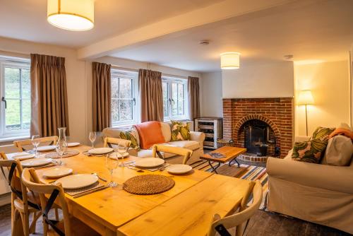 a living room with a wooden table and a fireplace at Skylark Cottage at Seven Sisters in West Dean