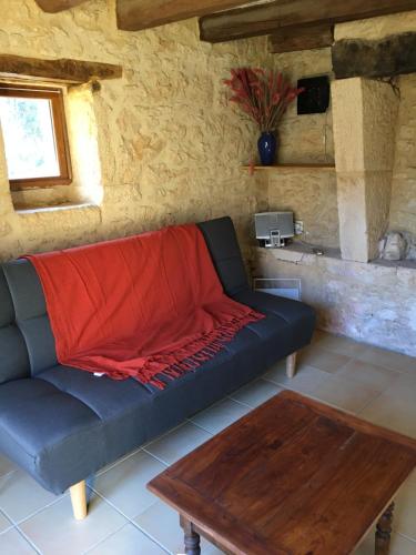 ein Wohnzimmer mit einem Sofa und einem Tisch in der Unterkunft Le Pas de la Lande in Groléjac
