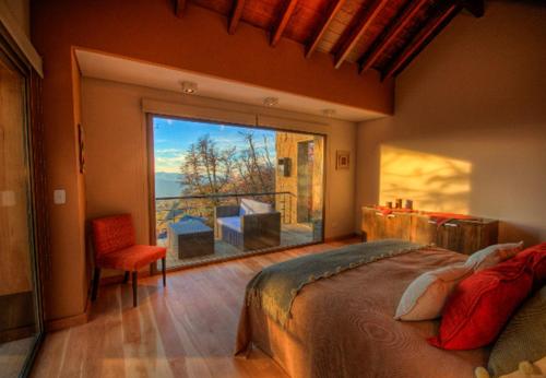 1 dormitorio con cama y ventana grande en RentUp - Vistas al Volcan Lanin y Cordillera de los Andes en San Martín de los Andes
