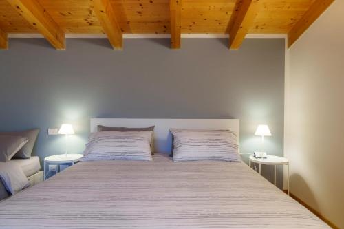 a bedroom with a large bed with two lamps at Bergamo bnb in Villa di Serio
