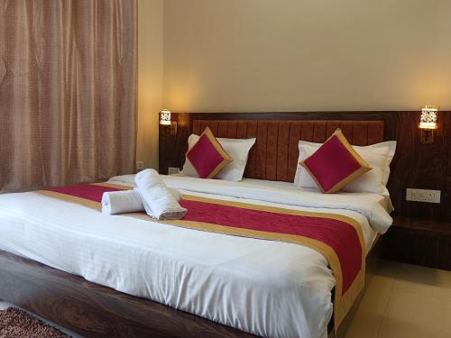 a bedroom with a large bed with two pillows at Happy Homes in Varanasi