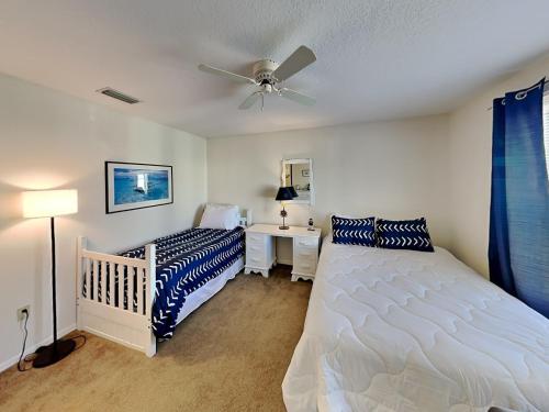 1 dormitorio con cama, escritorio y ventilador de techo en Seascape Beachhouse, en Crescent Beach