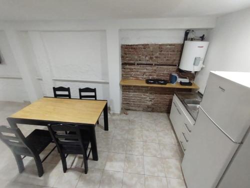 a small kitchen with a table and a refrigerator at Departamento Temporario Bianchi in Santiago del Estero