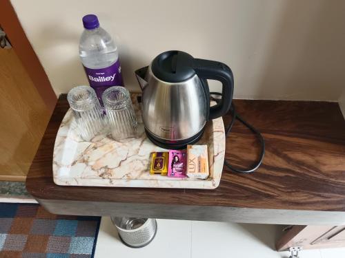 瓦拉納西的住宿－Happy Homes，桌子上的茶壶和一瓶水