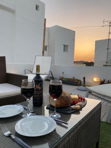 a table with two glasses of wine and a plate of food at Traditional Maltese Townhouse - Close to Sea in Senglea