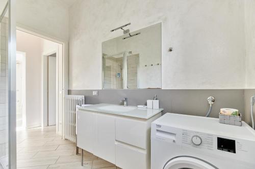 a white bathroom with a washing machine and a mirror at App. Mimosa Minerva Holiday Home in Manerba del Garda