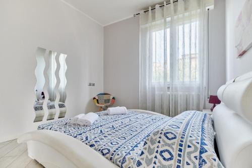 a white bedroom with a bed and a window at App. Mimosa Minerva Holiday Home in Manerba del Garda