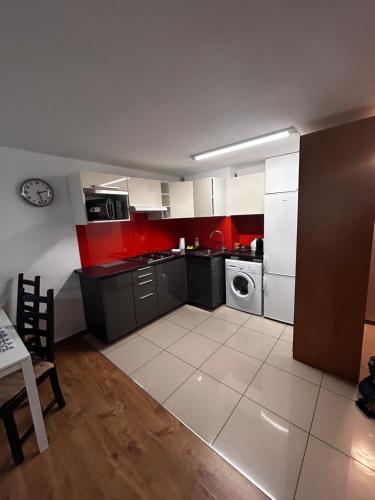 a kitchen with red and white cabinets and a stove at Apartament KOMETA Śródmieście in Warsaw