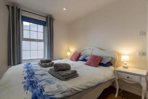 a bedroom with a bed with two chairs and a window at Sea View Cottage, Sandgate in Sandgate