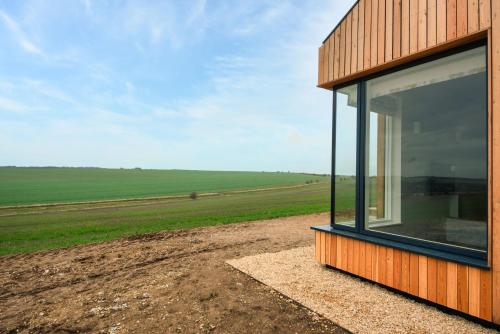 a house with a large window on the side of a field at Downs in Blewbury