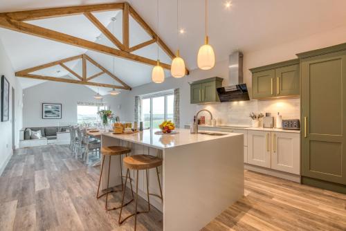 a kitchen with green cabinets and a large island at Downs in Blewbury