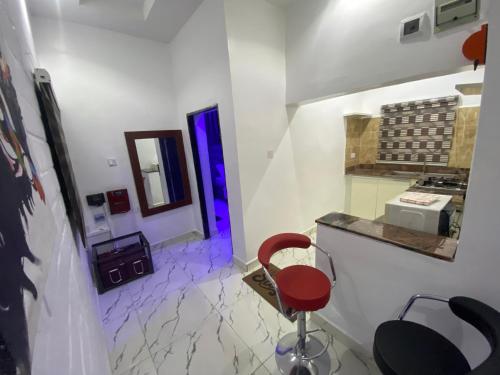 a room with a counter and a red chair in it at Merryway Apartments in Abuja