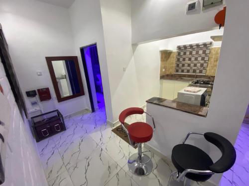 a room with two chairs and a counter with purple lights at Merryway Apartments in Abuja