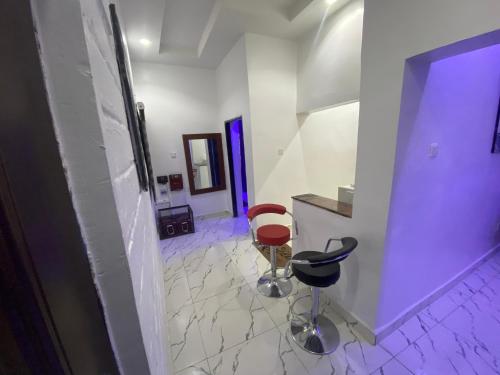 a hallway with two stools and a counter in a room at Merryway Apartments in Abuja