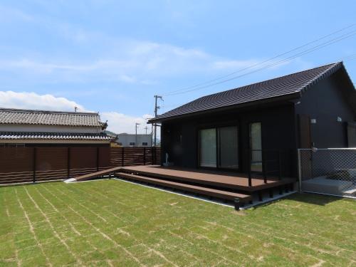 a black house with a deck and a yard at -HITOTOKI- 家族とペットと他愛もないhitotokiを in Tusi