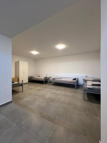 a room with three beds in a room with a tile floor at Mieterlux Frankfurt Heusenstamm in Heusenstamm