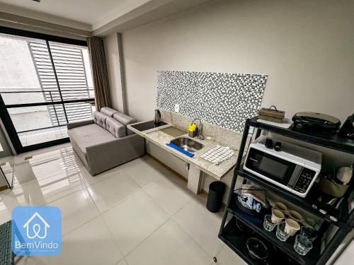a small living room with a sink and a microwave at Studio na Av. Oceânica House Barra in Salvador