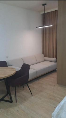 a living room with a white couch and a table at Almare Batumi in Batumi