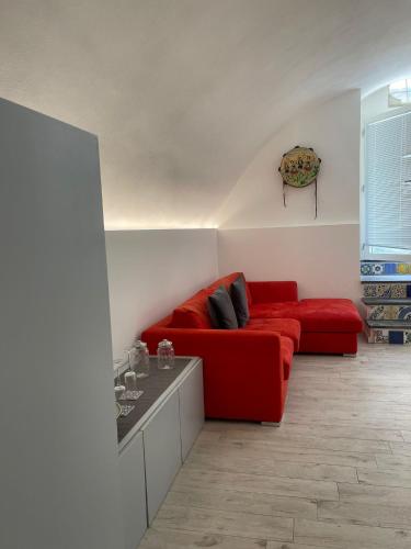 a living room with a red couch and a table at Civico 21 in Noto