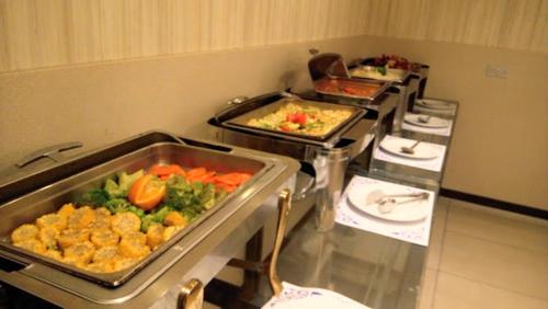 una cocina con varias bandejas de comida en una mesa en Arena By Trend, en Amán