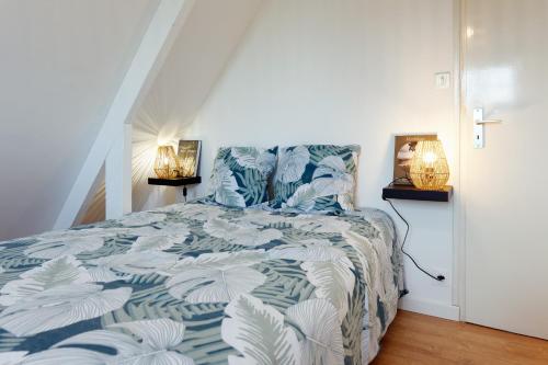 um quarto com uma cama com um edredão azul e branco em Entre Golfe et Océan em La Trinité-Surzur