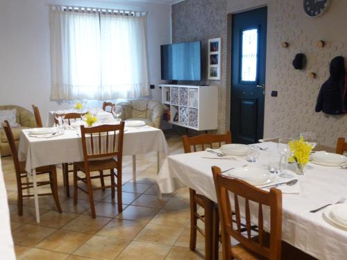 a dining room with white tables and chairs and a tv at Bonaventura b&b and Bonaventura food in Tollo