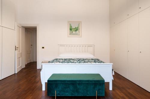 um quarto com uma cama branca e um repousa-pés verde em Summer Breeze Family Aparment by Wonderful Italy em Bari
