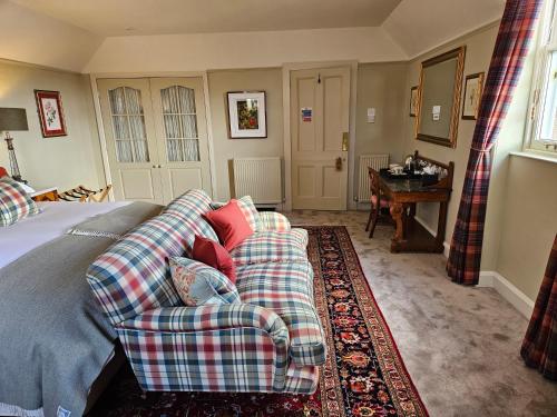 a bedroom with a bed with a plaid couch at Craggan in Ballater