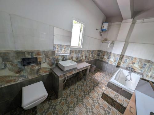 een badkamer met een wastafel, een toilet en een bad bij RT Mutbu in Aizawl