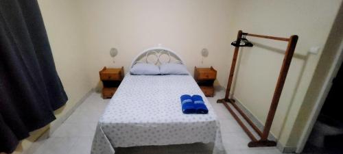 a bedroom with a bed with blue slippers on it at OpenSky in São Filipe