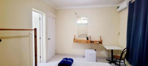 a room with a bed and a desk and a window at OpenSky in São Filipe