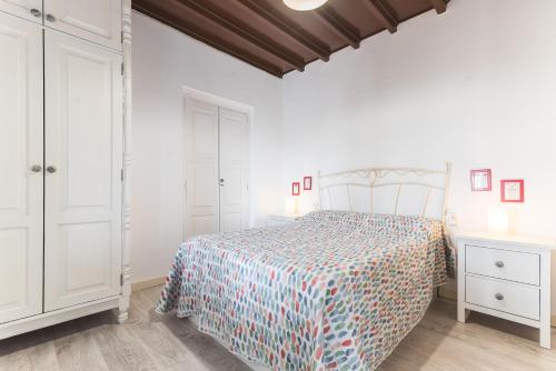 メレナラにあるHome2Book Oceanfront Bliss in Taliarteの白いベッドルーム(ベッド1台、白いキャビネット付)