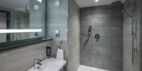 Maldron Hotel Shoreditch London في لندن: حمام مع حوض ودش