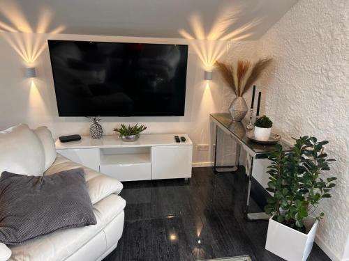 a living room with a white couch and a flat screen tv at In der Leite in Oberstdorf