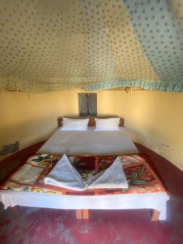 a pair of beds in a room with a roof at Jaisalmer Safari Base & Camp in Khuri